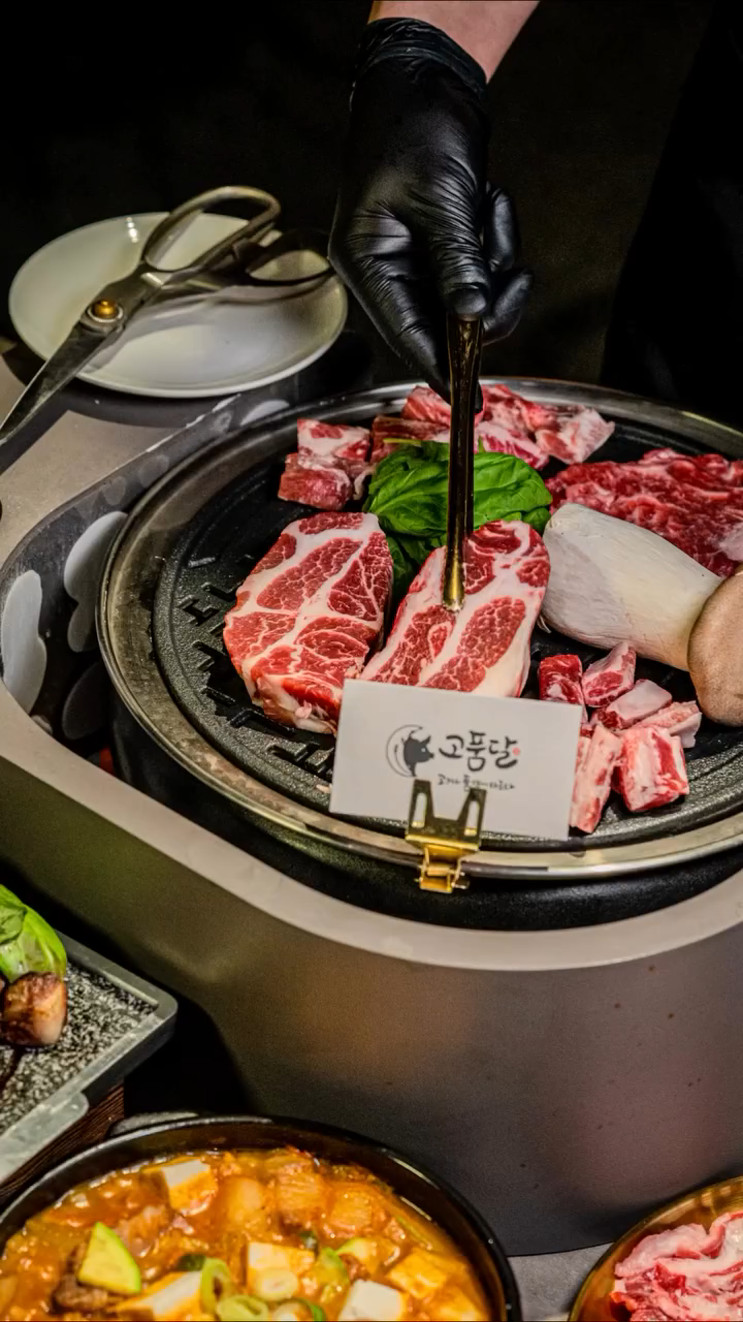 한우 위에 깻잎 올리는 손과 매장 명패